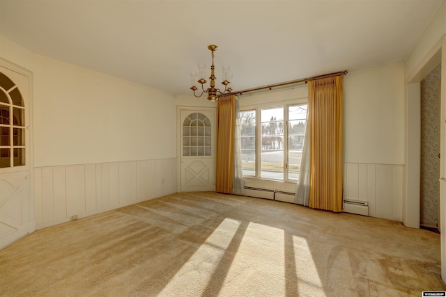 unfurnished room featuring light carpet, a baseboard radiator, and an inviting chandelier