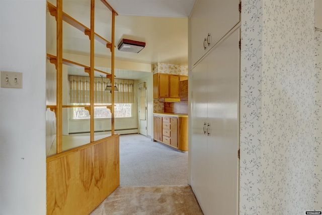 kitchen featuring decorative backsplash, light colored carpet, and a baseboard heating unit