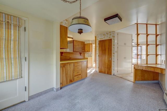 kitchen with light carpet and hanging light fixtures