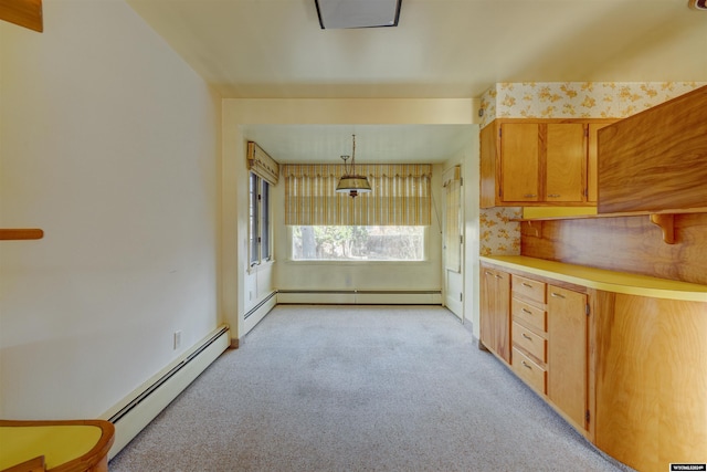 kitchen with light carpet, decorative light fixtures, and a baseboard heating unit