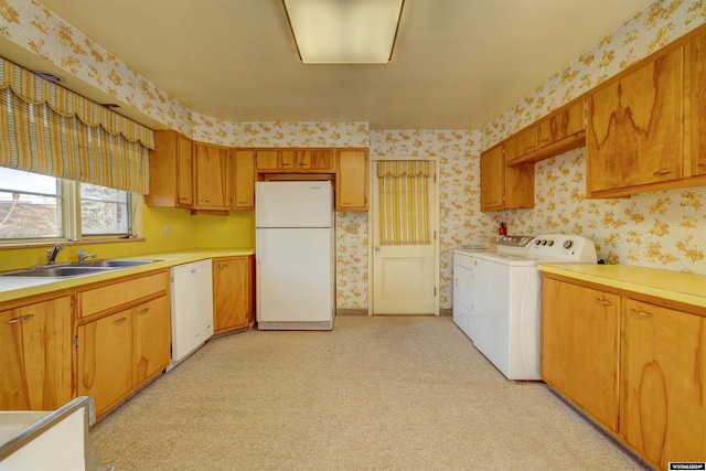 kitchen featuring washing machine and clothes dryer, white appliances, light colored carpet, and sink