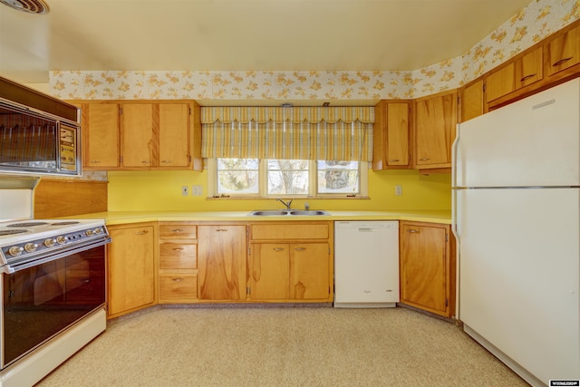 kitchen with white appliances, sink, and light carpet