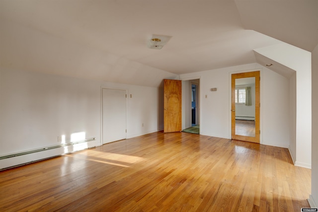 bonus room with baseboard heating, light hardwood / wood-style flooring, and lofted ceiling