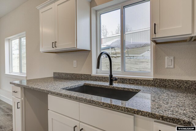 600 Badger Ln, Mills, WY 82644 - kitchen with stone counters, wood-type flooring, white cabinetry, and sink