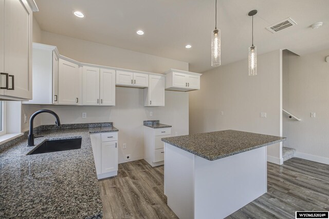 600 Badger Ln, Mills, WY 82644 - kitchen with a center island, sink, white cabinets, and hardwood / wood-style floors