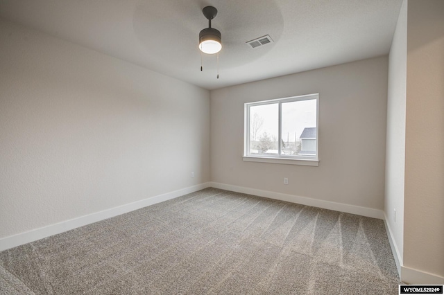 empty room featuring ceiling fan and carpet