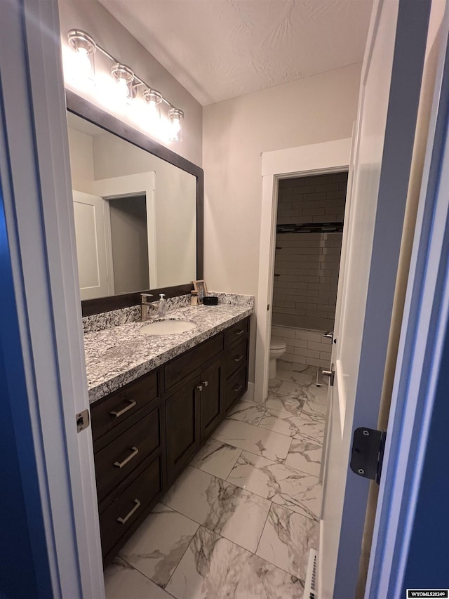 full bathroom with vanity, a textured ceiling, walk in shower, toilet, and marble finish floor