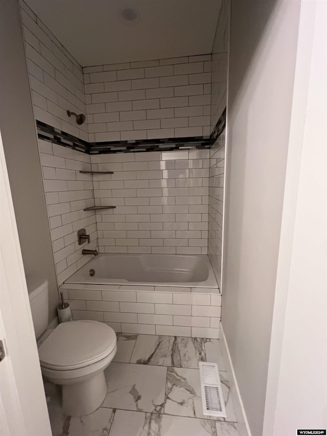 full bathroom with visible vents, baseboards, toilet, marble finish floor, and tiled shower / bath