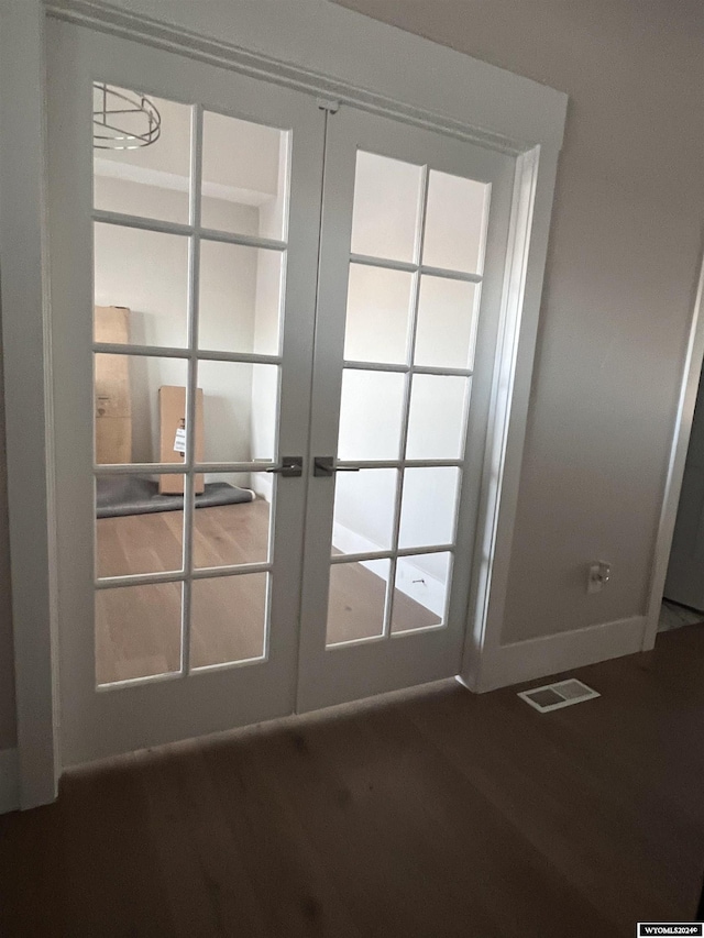 entryway with dark wood finished floors, visible vents, french doors, and baseboards