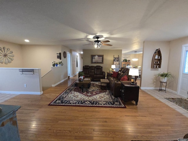 living room featuring hardwood / wood-style floors and ceiling fan