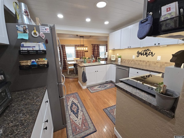 kitchen featuring pendant lighting, sink, stainless steel appliances, and white cabinets