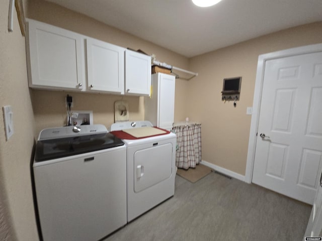 washroom with cabinets and washing machine and dryer