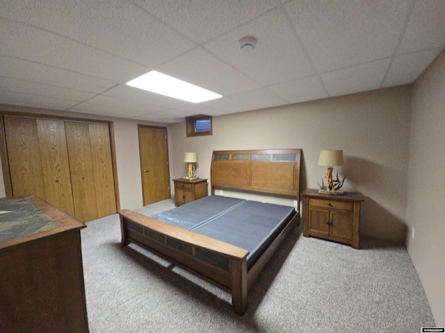 carpeted bedroom with a paneled ceiling