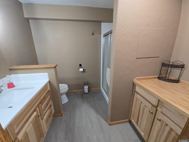 bathroom featuring an enclosed shower, vanity, hardwood / wood-style flooring, and toilet