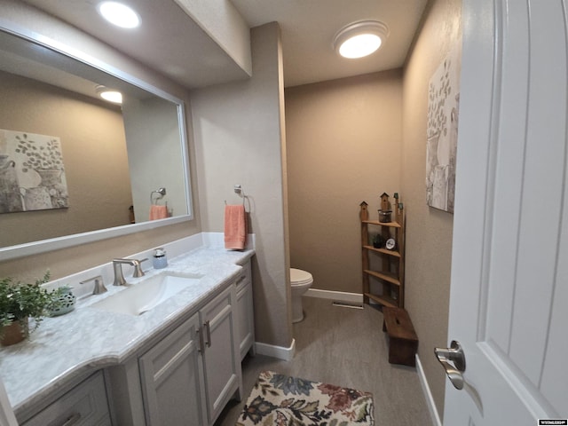 bathroom featuring vanity, toilet, and hardwood / wood-style floors