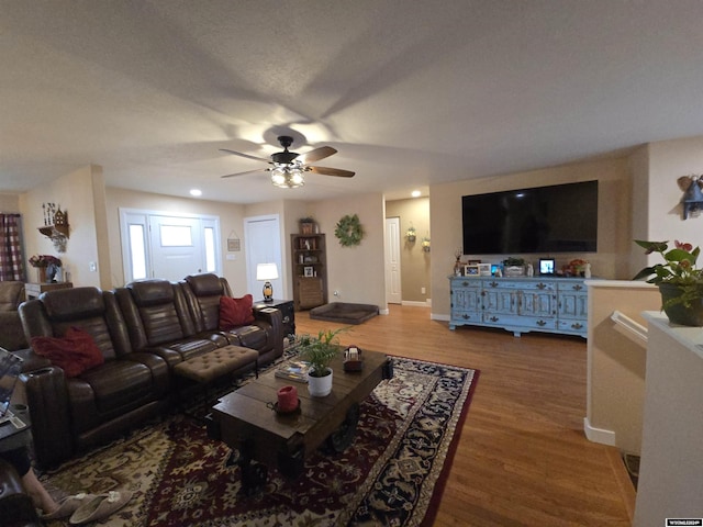 living room with wood-type flooring and ceiling fan