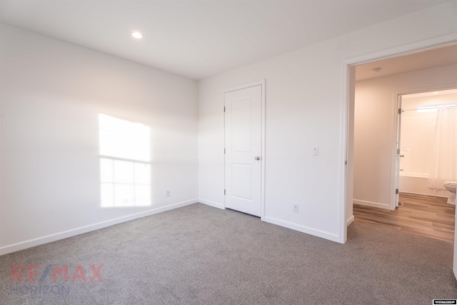 unfurnished bedroom with carpet flooring and connected bathroom