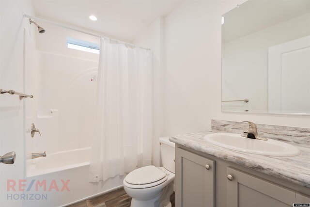 full bathroom featuring shower / tub combo with curtain, vanity, wood-type flooring, and toilet