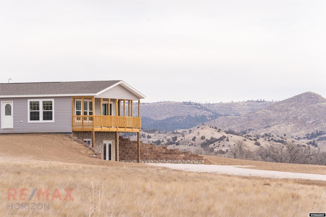 rear view of property featuring a deck with mountain view