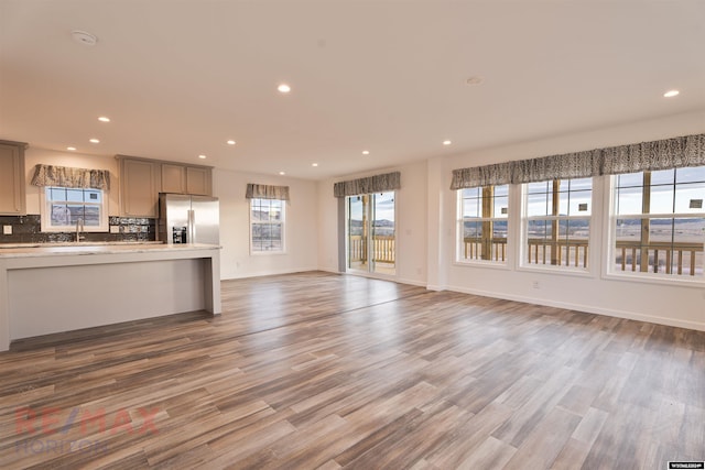 unfurnished living room featuring wood-type flooring and sink