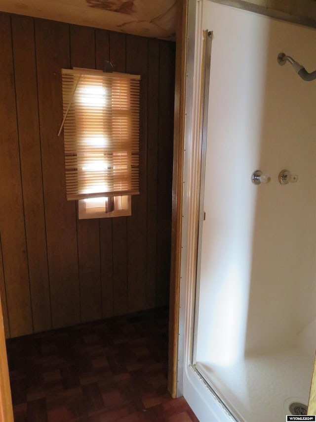 corridor with dark parquet flooring and wood walls