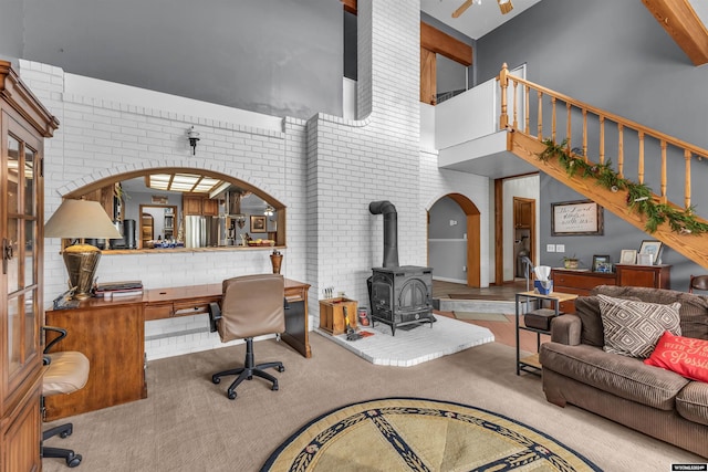 9 Spotted Tail Cir, Rock Springs, WY 82901 - living room featuring a high ceiling, a wood stove, carpet floors, a desk, and brick wall