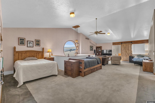 9 Spotted Tail Cir, Rock Springs, WY 82901 - bedroom with carpet flooring, a barn door, vaulted ceiling, and a ceiling fan
