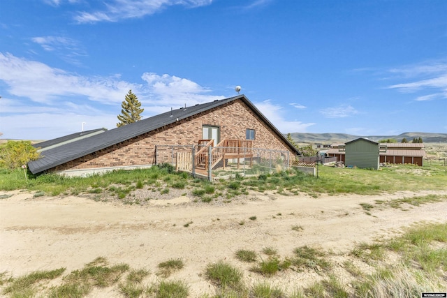 9 Spotted Tail Cir, Rock Springs, WY 82901 - view of side of home with brick siding and a deck with mountain view