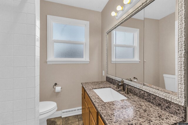 bathroom featuring tile patterned floors, vanity, toilet, and a baseboard heating unit