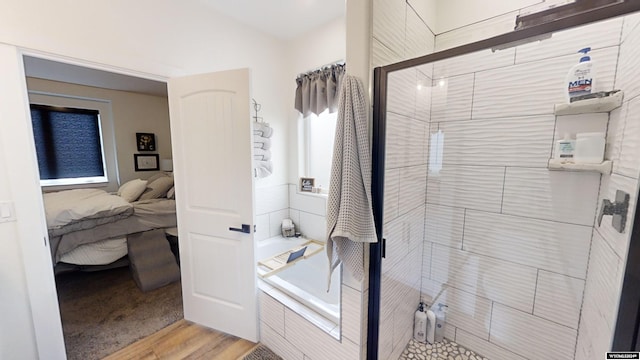 bathroom with hardwood / wood-style floors and separate shower and tub