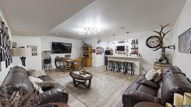 living room featuring light hardwood / wood-style flooring and a textured ceiling