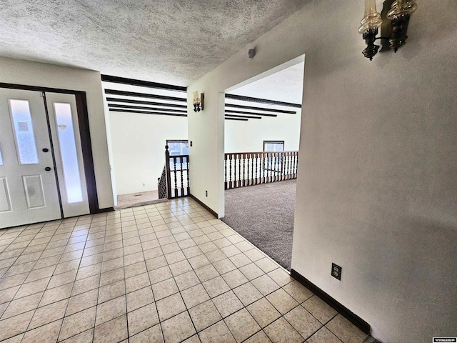 carpeted entryway with a textured ceiling and a wealth of natural light