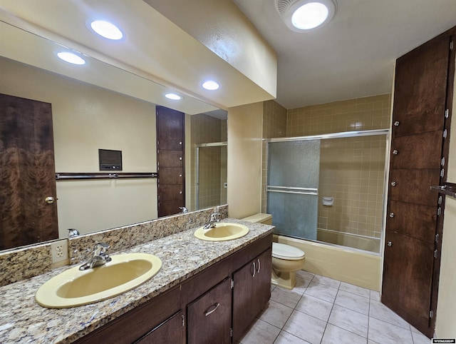 full bathroom featuring tile patterned floors, vanity, toilet, and bath / shower combo with glass door