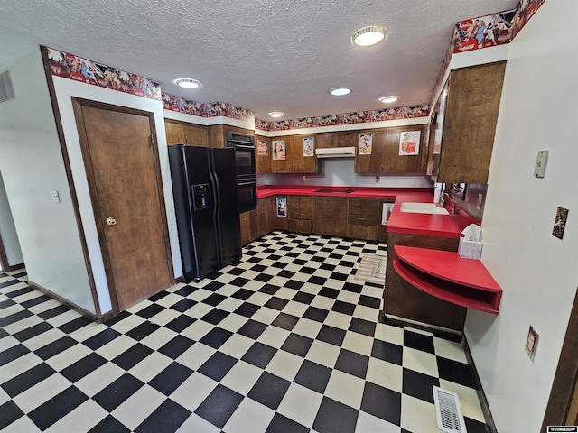 kitchen with a textured ceiling, sink, and black appliances