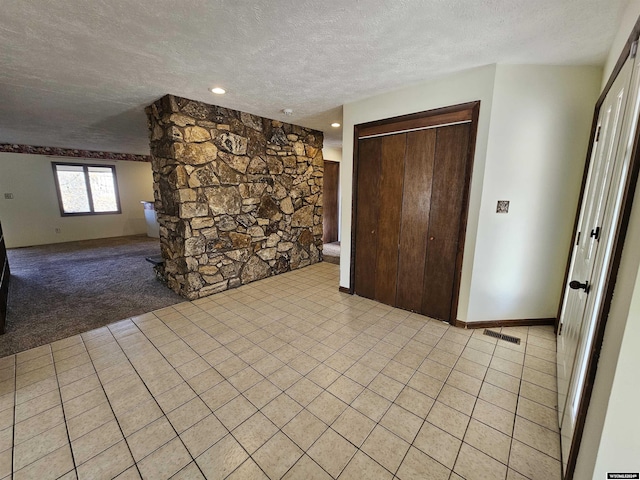 interior space with light tile patterned flooring and a textured ceiling