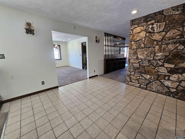 carpeted spare room with a textured ceiling