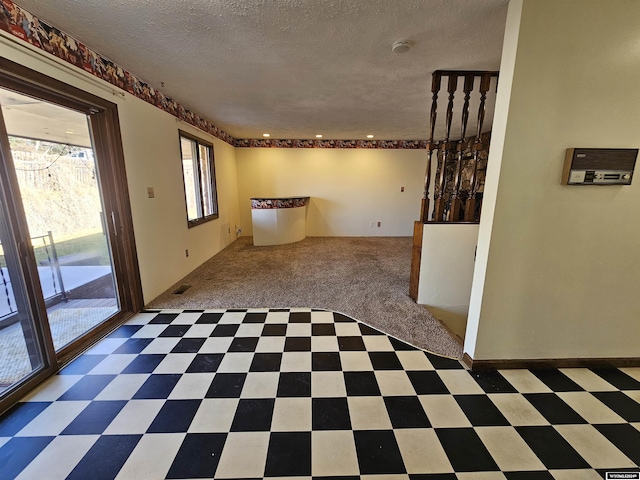 empty room with dark colored carpet and a textured ceiling