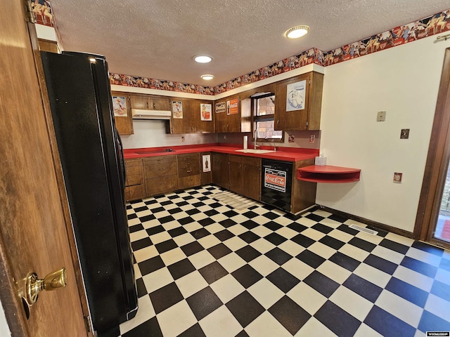 kitchen featuring black appliances, sink, and a textured ceiling