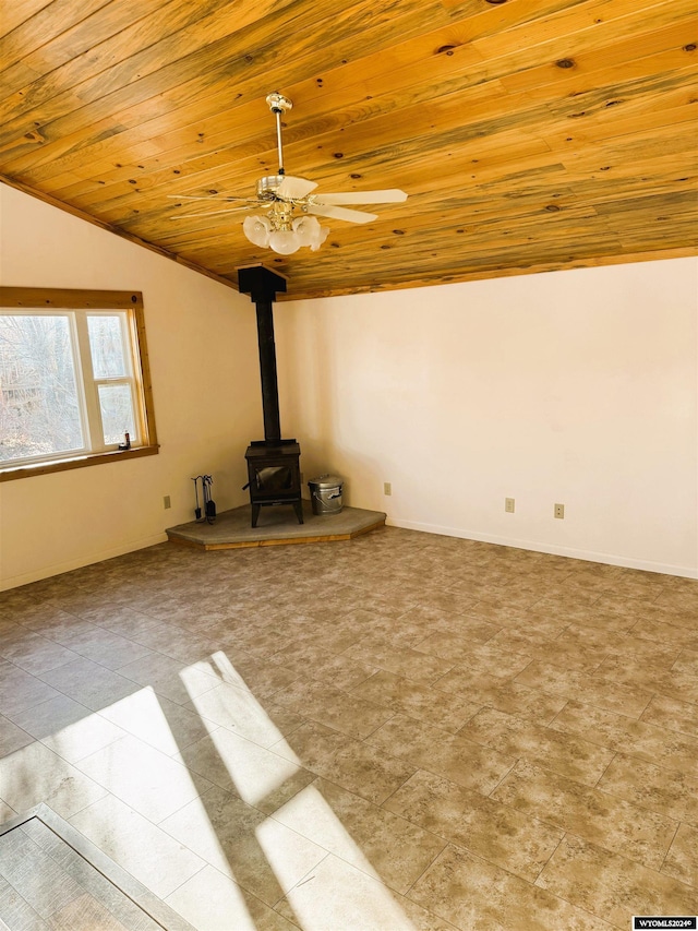 unfurnished living room with vaulted ceiling, a wood stove, ceiling fan, and wood ceiling