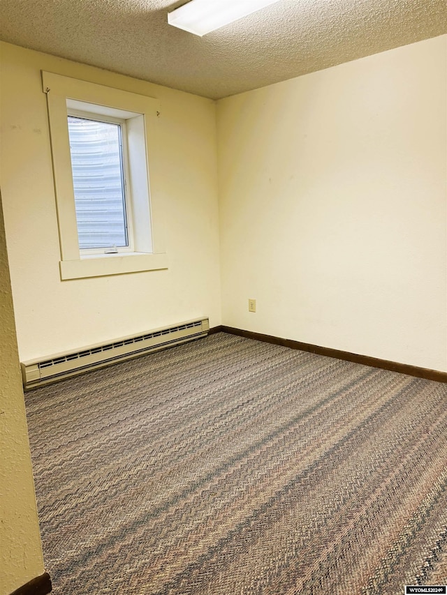 carpeted empty room with a textured ceiling and a baseboard heating unit