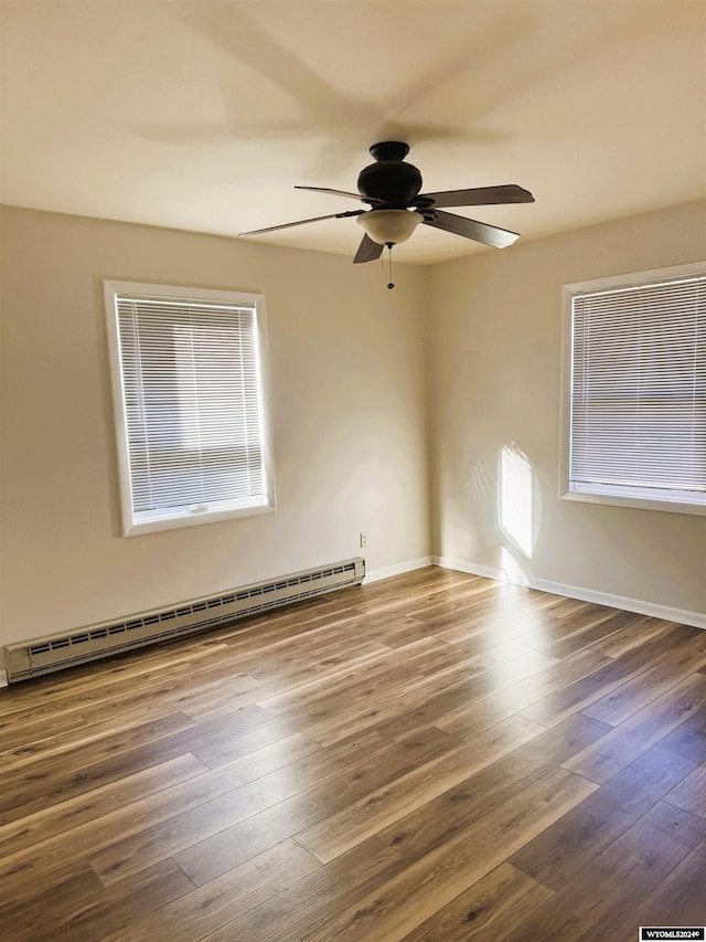 empty room featuring baseboard heating, ceiling fan, and dark hardwood / wood-style flooring