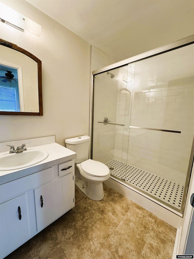 bathroom with vanity, toilet, and a shower with door