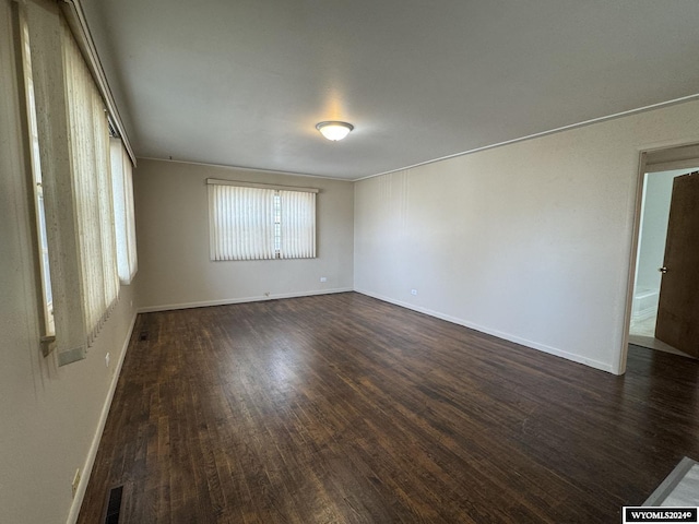 spare room with dark hardwood / wood-style flooring