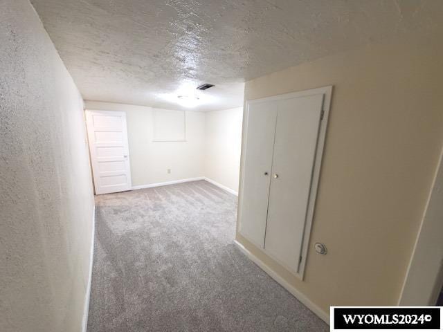 basement with light carpet and a textured ceiling