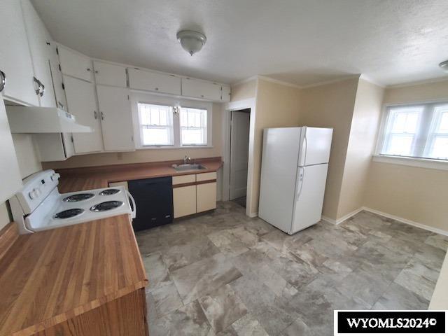 kitchen with white cabinetry, sink, a healthy amount of sunlight, and white appliances