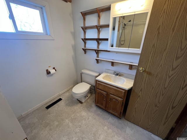 bathroom featuring a shower, vanity, and toilet