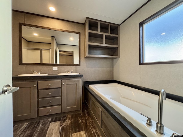 bathroom with a tub, vanity, and wood-type flooring