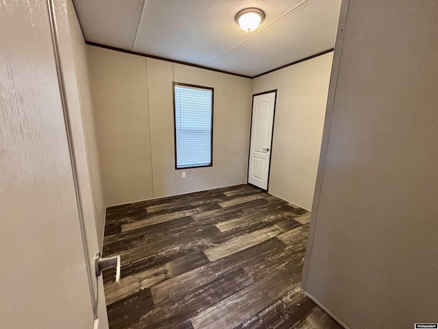 empty room featuring a textured ceiling and dark hardwood / wood-style flooring