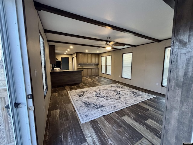 unfurnished living room with beam ceiling, ceiling fan, and dark hardwood / wood-style floors