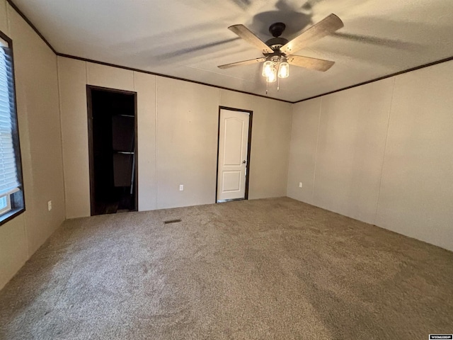 carpeted empty room with ceiling fan and ornamental molding